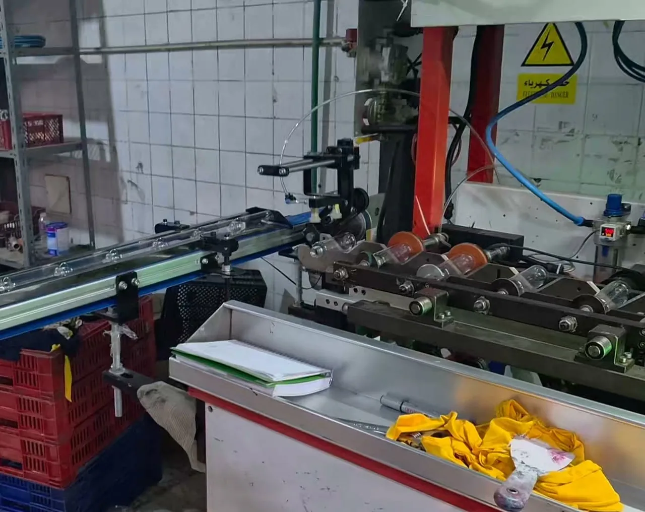 Bottle printing machine with a conveyor and roller fixtures holding clear bottles