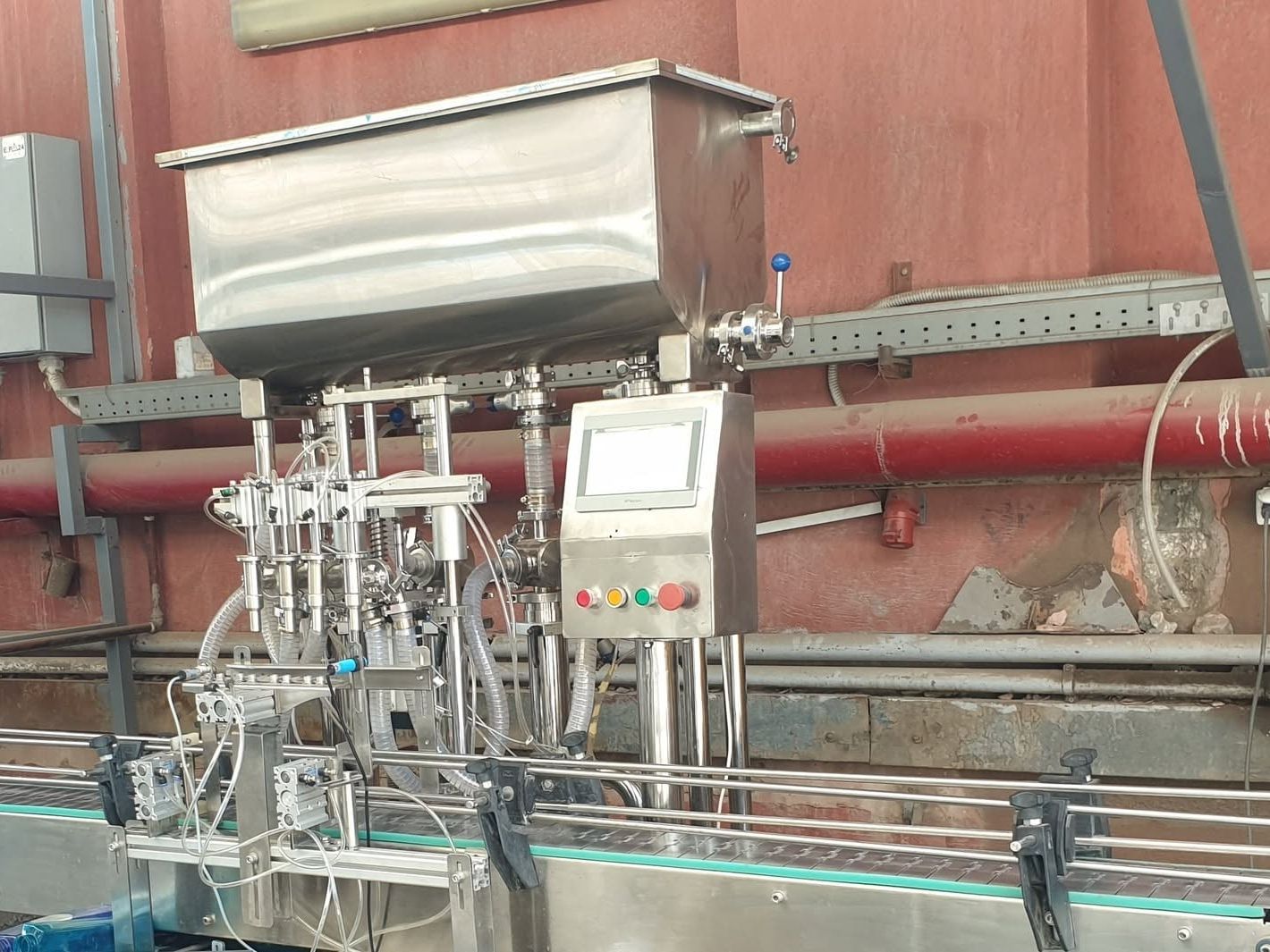 Four-nozzle piston filling machine with a stainless-steel hopper, conveyor and operator push-button box