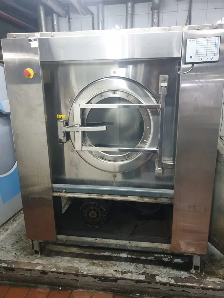 Stainless-steel front-loading washer-extractor in a hotel laundry room