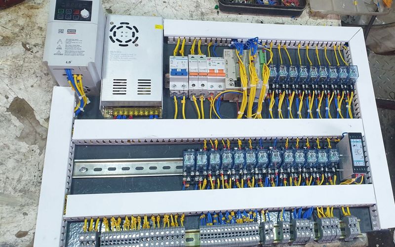 Newly wired control panel with an LS Electric M100 drive, power supply, Delta PLC, circuit breakers and two rows of relays