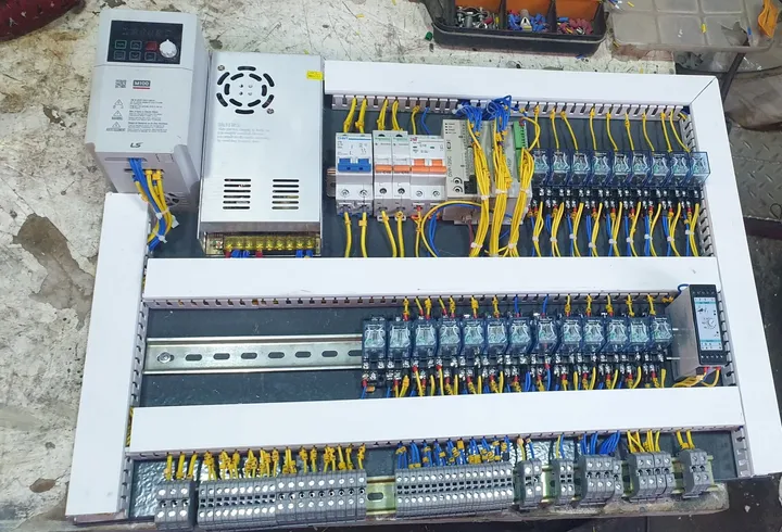 Newly wired control panel with an LS Electric M100 drive, power supply, Delta PLC, circuit breakers and two rows of relays